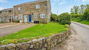 A stone building with a paved driveway and a grassy lawn. - 2 Bed in St. Issey (oc-t29235) (Saint Issey)
