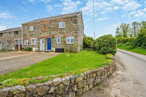 A stone building with a paved driveway and a grassy lawn. - 2 Bed in St. Issey (oc-t29235) (Saint Issey)