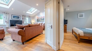 A spacious room with a sofa, a bed, a TV, and a skylight. - 3 Bed in Freshwater East (oc-w29240) (Freshwater East)