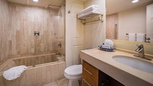 A modern bathroom with a walk-in shower, a toilet, a sink with a mirror, and a towel rack. - Cabo Beachfront condo for Holidays (Cabo San Lucas)