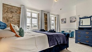 Een slaapkamer met een groot bed, een dressoir en een spiegel.