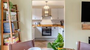 A compact kitchen with white cabinets, a built-in oven, and a wooden countertop. - 2 Bed in Holt (oc-f29274) (Holt)