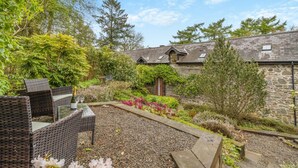 A stone building with a garden area, outdoor seating, and a gravel path. - 2 Bed in Knighton (oc-t29330) (Felindre)