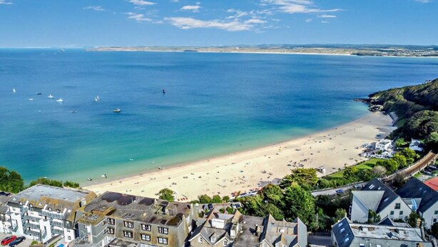 A coastal town with a sandy beach, boats on the water, and buildings in the foreground. - 1 Bed in St. Ives (oc-l29205) (St Ives)