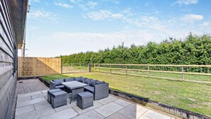 An outdoor patio with a seating area, stone flooring, and a wooden fence. - 2 Bed in Feering (oc-p29293) (Feering)