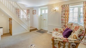 A staircase leading to a door, a floral-patterned sofa, and a radiator. - 2 Bed in Holt (oc-m29326) (Holt)