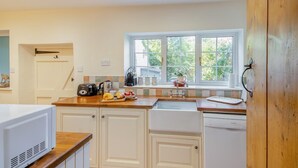 A kitchen with white cabinets, a wooden countertop, a window with a view of greenery, and a sink. - 2 Bed in Holt (oc-m29326) (Holt)