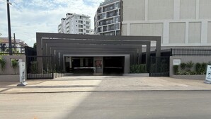 En modern entré till en byggnad med en uppfart som har grind, en skylt som visar att det endast är tillträde för besökare på anläggningen, och en skylt som säger "PARKERING FÖRBJUDEN".