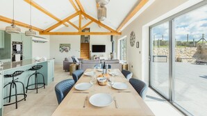 Uma cozinha moderna com área de refeições, grandes janelas e vista para o exterior.