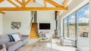 Uma sala de estar moderna com lareira, sofá, mesa de centro e televisão.