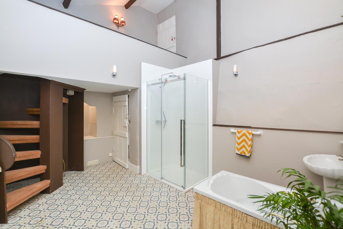 A modern bathroom with a shower, a bathtub, and a sink.