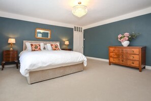 A bedroom with a bed, nightstands, a dresser, a mirror, and a chandelier. - 5 Bed in Winkleigh (oc-g29214) (Winkleigh)