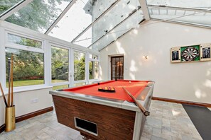 A pool table in a room with large windows, a dartboard, and a door leading outside. - 5 Bed in Winkleigh (oc-g29214) (Winkleigh)