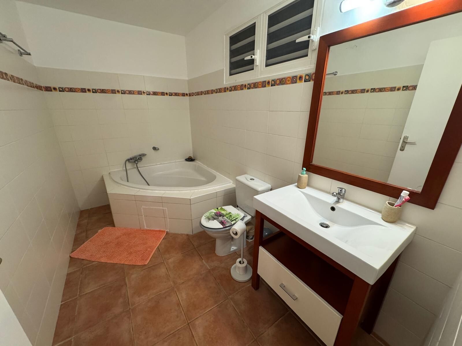 Un baño con bañera, inodoro, lavabo y espejo.