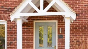 A brick building with a grey door, a white porch, and a sign reading "Meadow View".