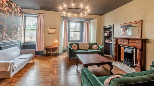 A living room with a fireplace, a green sofa, a white sofa, and a wooden coffee table. - 6 Bed in Alnwick (oc-b29336) (Alnwick)
