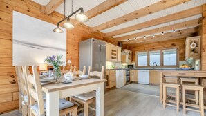 L’intérieur d’un chalet en bois comprend un coin repas, une cuisine et un bar.