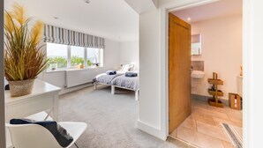 A bedroom with a bed, bedside table, and a window with a view. - 5 Bed in Aberdovey (oc-t29402) (Aberdovey)