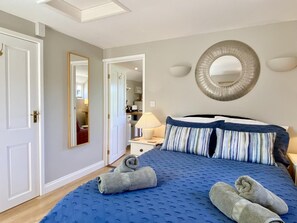 A bedroom with a large bed, a mirror, and a view into the adjacent room. - 1 Bed in Cratfield (oc-t29434) (Cratfield)