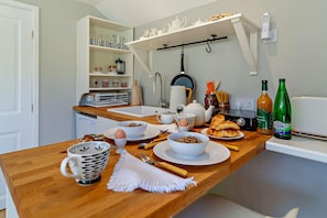 A breakfast setting with a wooden table, various dishes, a kettle, and bottles of juice. - 1 Bed in Cratfield (oc-t29434) (Cratfield)
