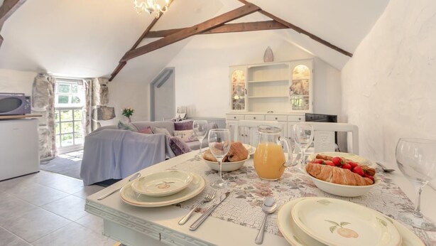 A dining area with a table set for breakfast, including croissants, strawberries, and juice. - 2 Bed in Trewoon (oc-t29504) (Saint Mewan)