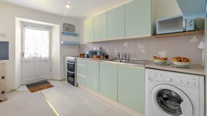 A compact kitchen with a washing machine, a microwave, and a toaster. - 2 Bed in Trewoon (oc-t29503) (Saint Mewan)