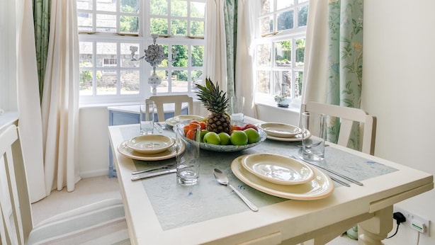 A dining table set with plates, cutlery, and a fruit bowl. - 2 Bed in Trewoon (oc-t29503) (Saint Mewan)