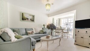 A living room with a grey sofa, a white coffee table, and a TV on a cabinet. - 2 Bed in Trewoon (oc-t29503) (Saint Mewan)