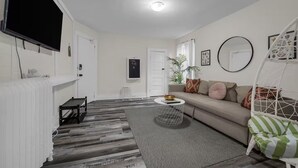 Ein modernes Wohnzimmer mit Sofa, Couchtisch und einer Hängesessel.