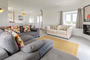 A modern living room with a grey sectional sofa, a white sofa, and a beige rug. - 2 Bed in St. Minver (oc-r29475) (Saint Minver)