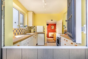A compact kitchen with a refrigerator, sink, and wooden cabinets. - 2 Bed in Reedham (oc-q29527) (Haddiscoe)