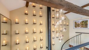 A modern interior with a wall-mounted candle display, a wooden beam ceiling, and a staircase. - 1 Bed in Reeth (oc-t29540) (Reeth)
