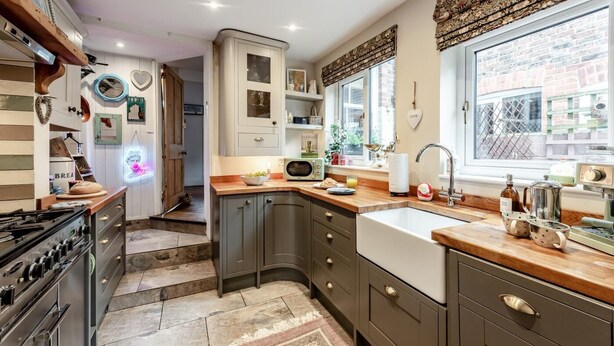 A kitchen with grey cabinets, a wooden countertop, a sink, and a window with a view of the outside. - 2 Bed in Rye (oc-86094) (Rye)