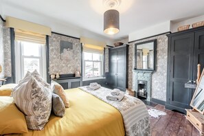 A bedroom with a large bed, a fireplace, a mirror, and a wardrobe. - 2 Bed in Rye (oc-86094) (Rye)