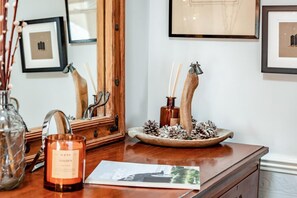 A wooden table with a candle, a framed picture, and a mirror. - 2 Bed in Rye (oc-86094) (Rye)