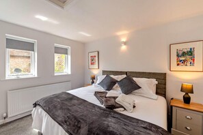 A hotel room with a bed, two bedside lamps, a radiator, a window with a view, and a framed picture on the wall. - 2 Bed in Chilham (oc-b29276) (Chilham)