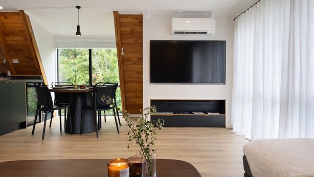 Ein modernes Wohnzimmer mit Essbereich, Flachbildfernseher und Kamin.
