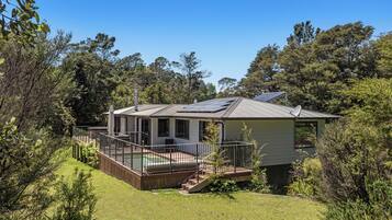 A house with a deck, a swimming pool, and a satellite dish.