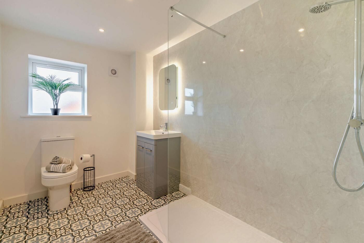 Ein modernes Badezimmer mit Toilette, Waschbecken und Dusche.