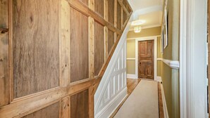 A hallway with wooden paneling and a carpeted floor, leading to a door at the end. - 1 Bed in Old Colwyn (oc-r29472) (Hen Golwyn)