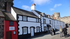 A traditional black and white building with a red door, labeled "The Smallest House in Great Britain." - 1 Bed in Old Colwyn (oc-r29472) (Hen Golwyn)
