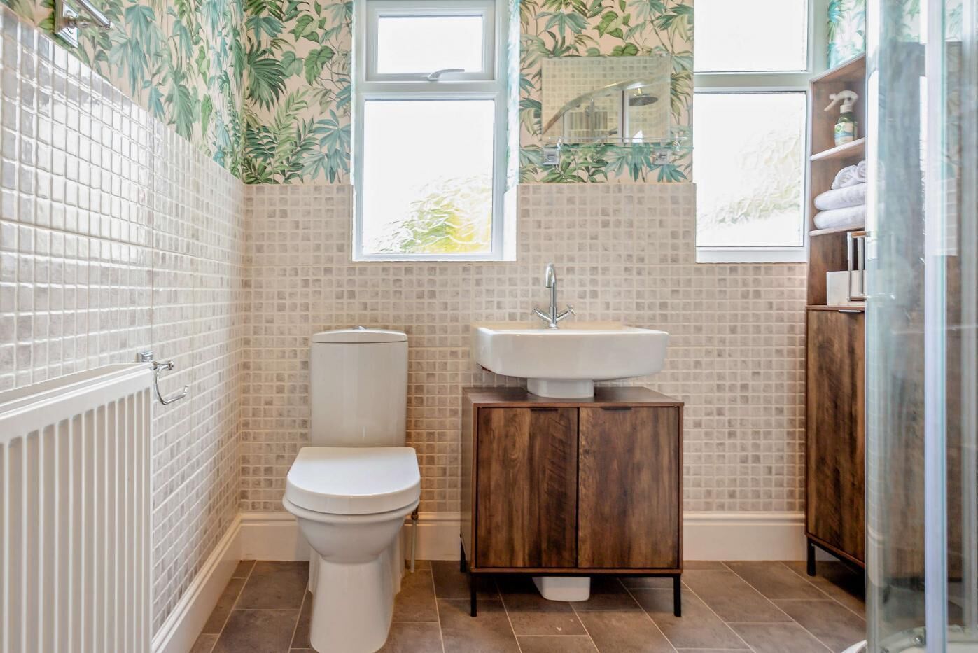 Een badkamer met toilet, wastafel en douche.