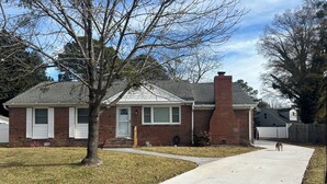 A residential house with a brick exterior, a chimney, and a front yard with a sidewalk. - Charming 1-bedroom in-law suite with functional kitchen in pleasant Portsmouth (Portsmouth)