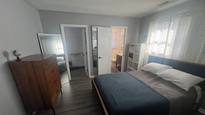A bedroom with a bed, dresser, and open closet doors. - Charming 1-bedroom in-law suite with functional kitchen in pleasant Portsmouth (Portsmouth)