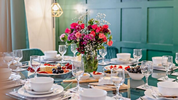 A dining table set with plates, glasses, and a centerpiece of flowers. - 6 Bed in Bridlington (oc-n29516) (Bridlington)
