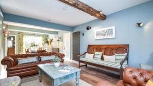 A living room with a brown leather sofa, a wooden bench, and a coffee table.