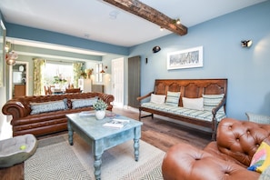 A living room with a brown leather sofa, a wooden bench, and a coffee table.