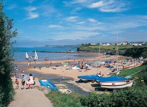 A beach scene with boats, people, and houses in the background. - 2 Bed in Devils Bridge (oc-d29575) (Pontarfynach)