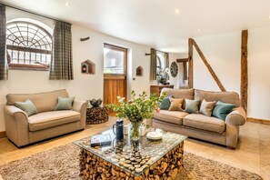 A living room with two sofas, a glass coffee table, and a rustic wooden beam. - 2 Bed in Lower Bodham (oc-p29591) (Bodham)
