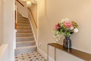 A staircase with a wooden handrail and a wall-mounted light fixture. - 2 Bed in Wells-next-the-Sea (oc-c29565) (Wells-next-the-Sea)